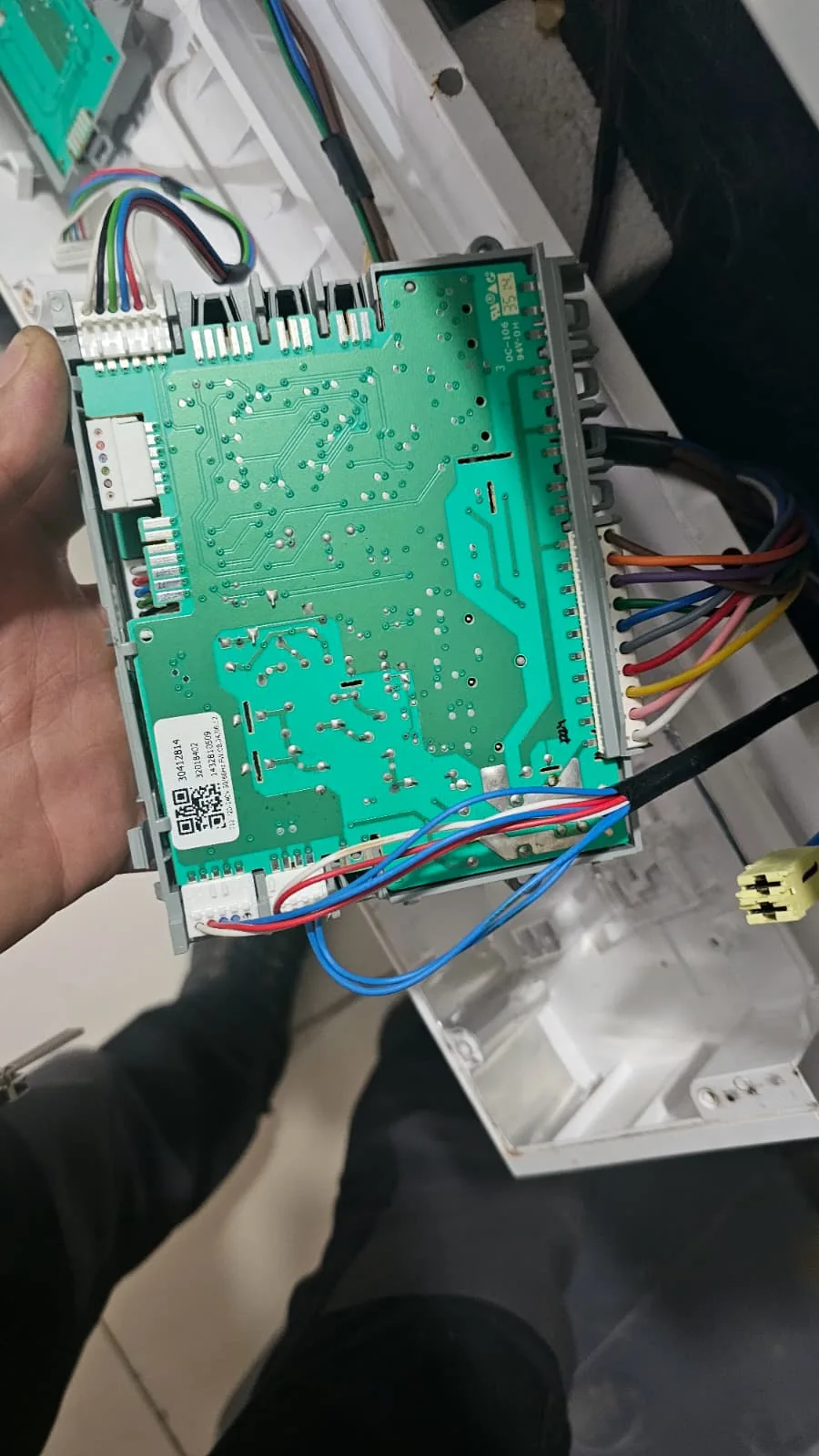 Çamaşır makinesinden sökülmüş kontrol modülü ve bağlantı soketleri servis görüntüsü